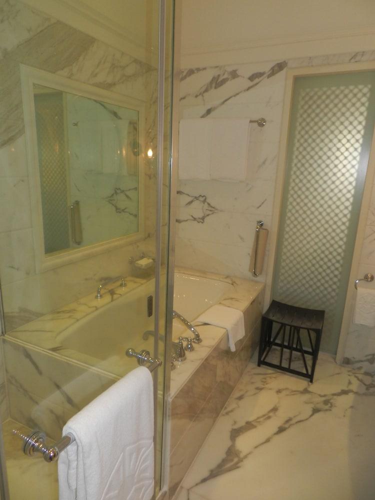 The Taj Mahal Tower, Mumbai Ξενοδοχείο Εξωτερικό φωτογραφία The photo displays a bathroom featuring a luxurious design. There is a glass-enclosed shower area alongside a large bathtub. The walls are adorned with marble, giving a sophisticated look. A few white towels are neatly arranged, and there is a small 