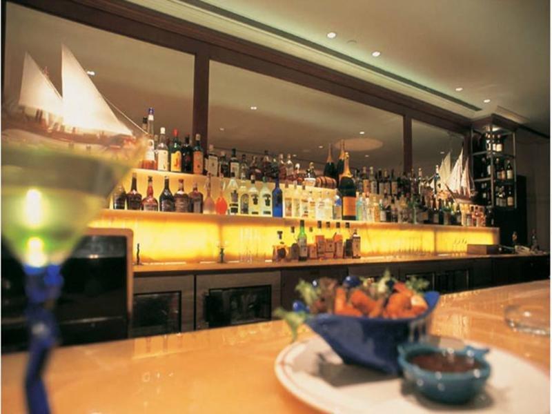 The Taj Mahal Tower, Mumbai Ξενοδοχείο Εξωτερικό φωτογραφία The photo depicts a stylish bar setting. In the background, there is a well-stocked bar shelf lined with numerous bottles of various alcoholic beverages, illuminated by soft lighting that creates a warm ambiance. The countertop appears to be smooth a