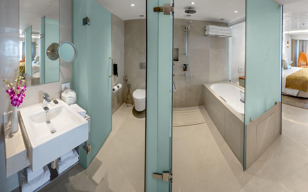 The Taj Mahal Tower, Mumbai Ξενοδοχείο Εξωτερικό φωτογραφία The photo shows a modern bathroom with a sleek design. To the left, there is a sink with a mirror above it, and beneath the sink, there are some storage shelves. The area also features a glass partition leading to a shower. On the right side, there i