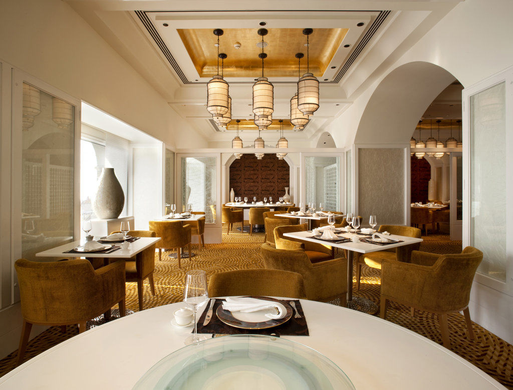 The Taj Mahal Tower, Mumbai Ξενοδοχείο Εξωτερικό φωτογραφία The photo shows an elegantly designed restaurant interior. The space features stylish furnishings, including round tables topped with white tablecloths and plush, mustard-colored chairs. The ceiling has a decorative design, with pendant lights hangin