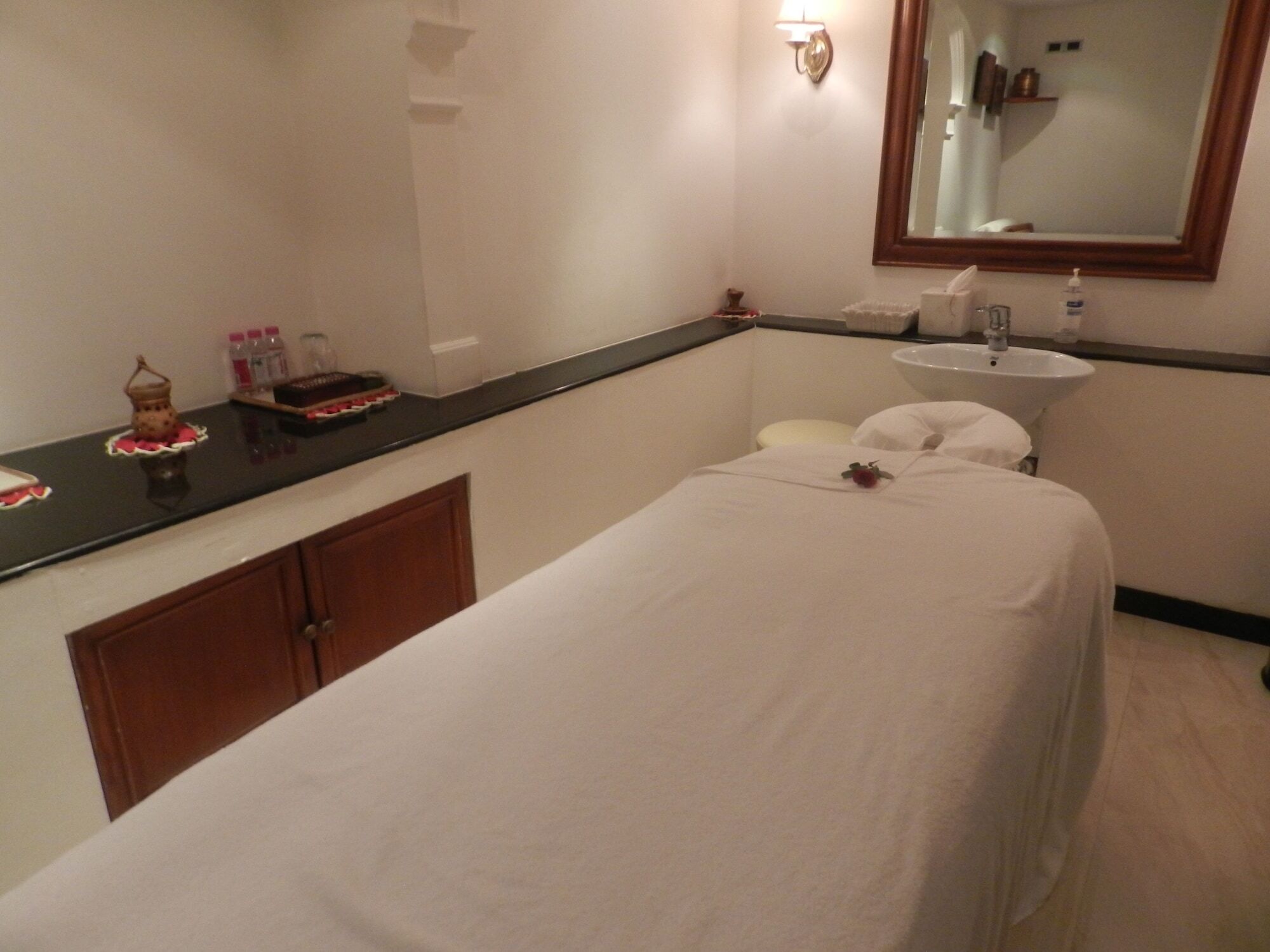The Taj Mahal Tower, Mumbai Ξενοδοχείο Εξωτερικό φωτογραφία The photo shows a serene spa room designed for relaxation and treatments. In the center, there is a massage table covered with a white sheet. There is a small decorative item, possibly a flower, placed on the table. Alongside, a dark countertop displ